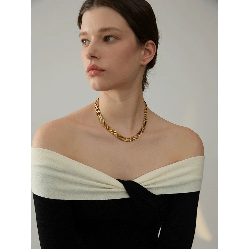 Gold jewelry necklace beside a matching gold bracelet in cuban chain gold