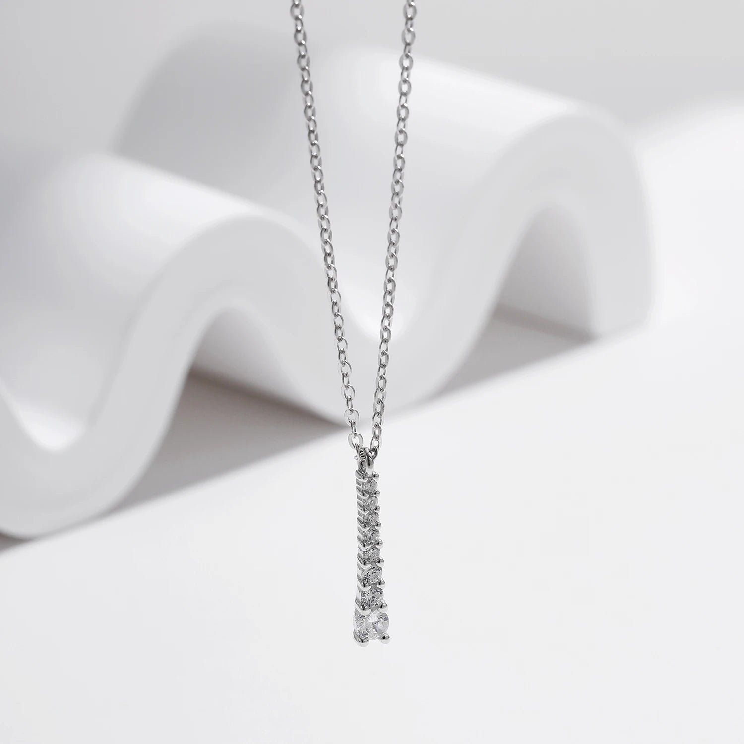 Moissanite jewelry pendant resting on a sterling silver chain