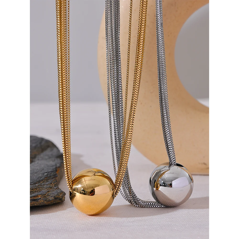 Charm necklace featuring layered chain and round ball pendant detail