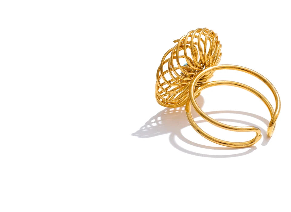 Minimal stone flower ring styled with bracelets and rings for golden jewelry coordination