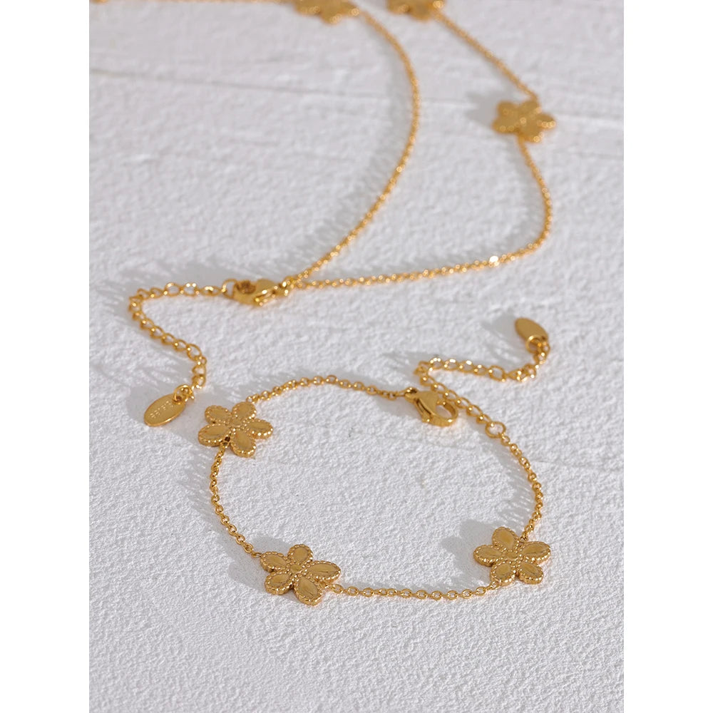 Flower bracelet charm next to chain gold chain in set view