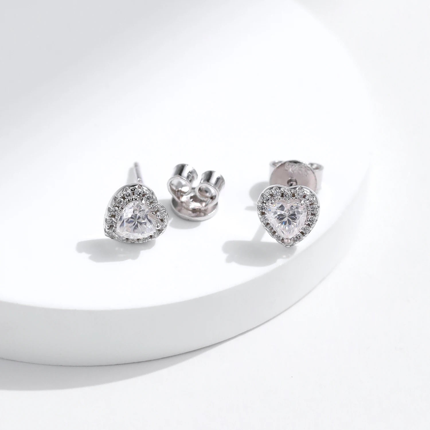 Refined ear rings featuring moissanite diamond centers in heart earrings