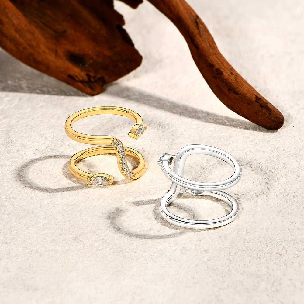 Gold and silver rings on a textured surface with wooden background