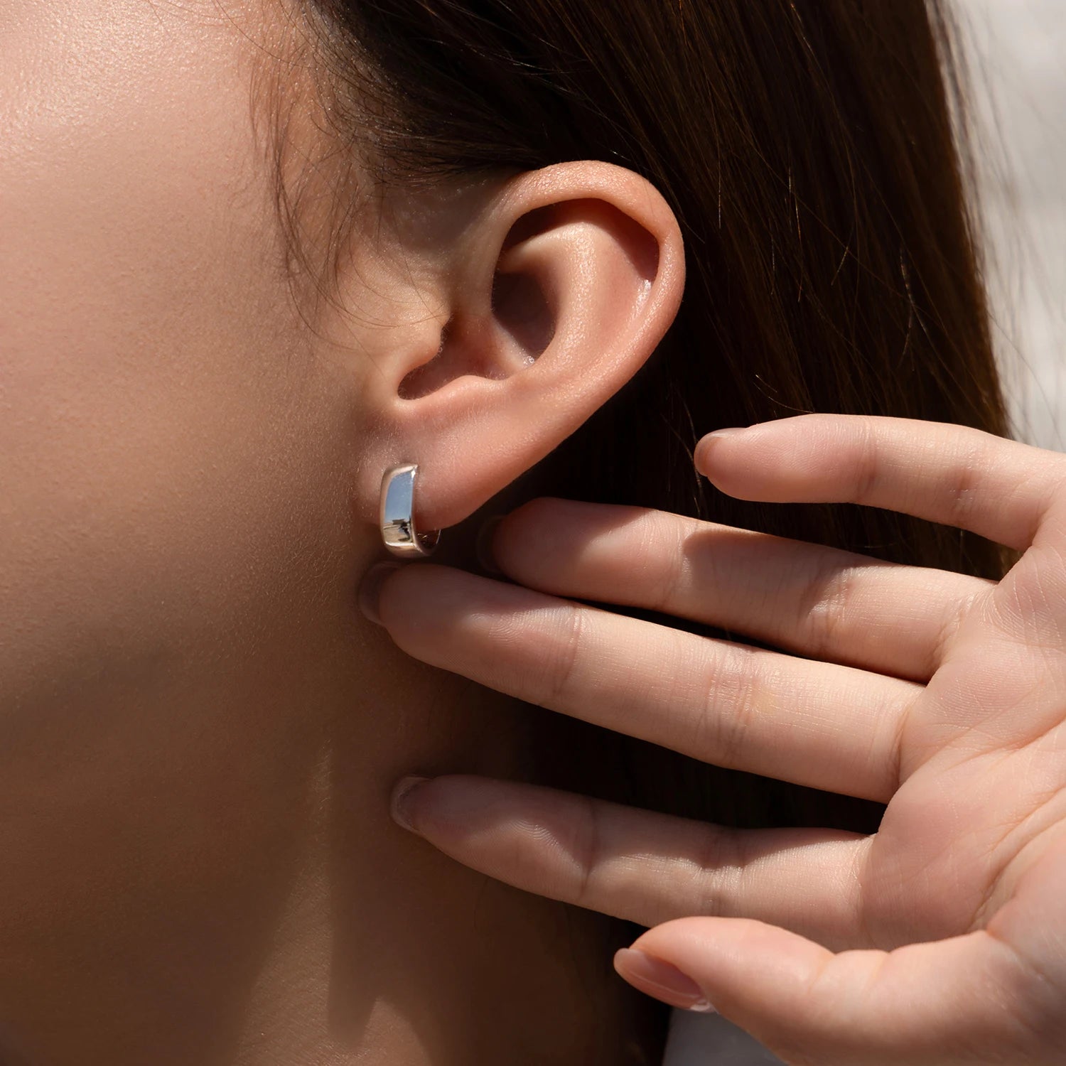 Close up of sterling silver earrings with smooth U shape design