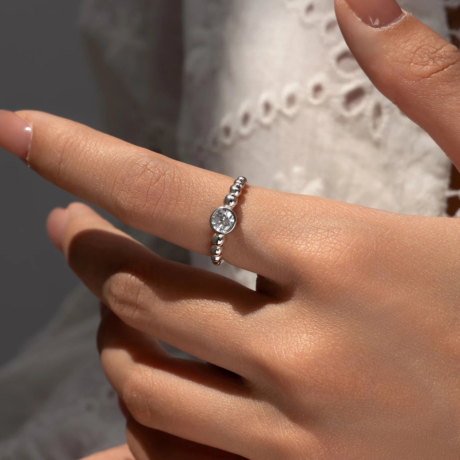 Hand wearing a ring stack featuring a 0.5CT VVS1 moissanite jewelry ring