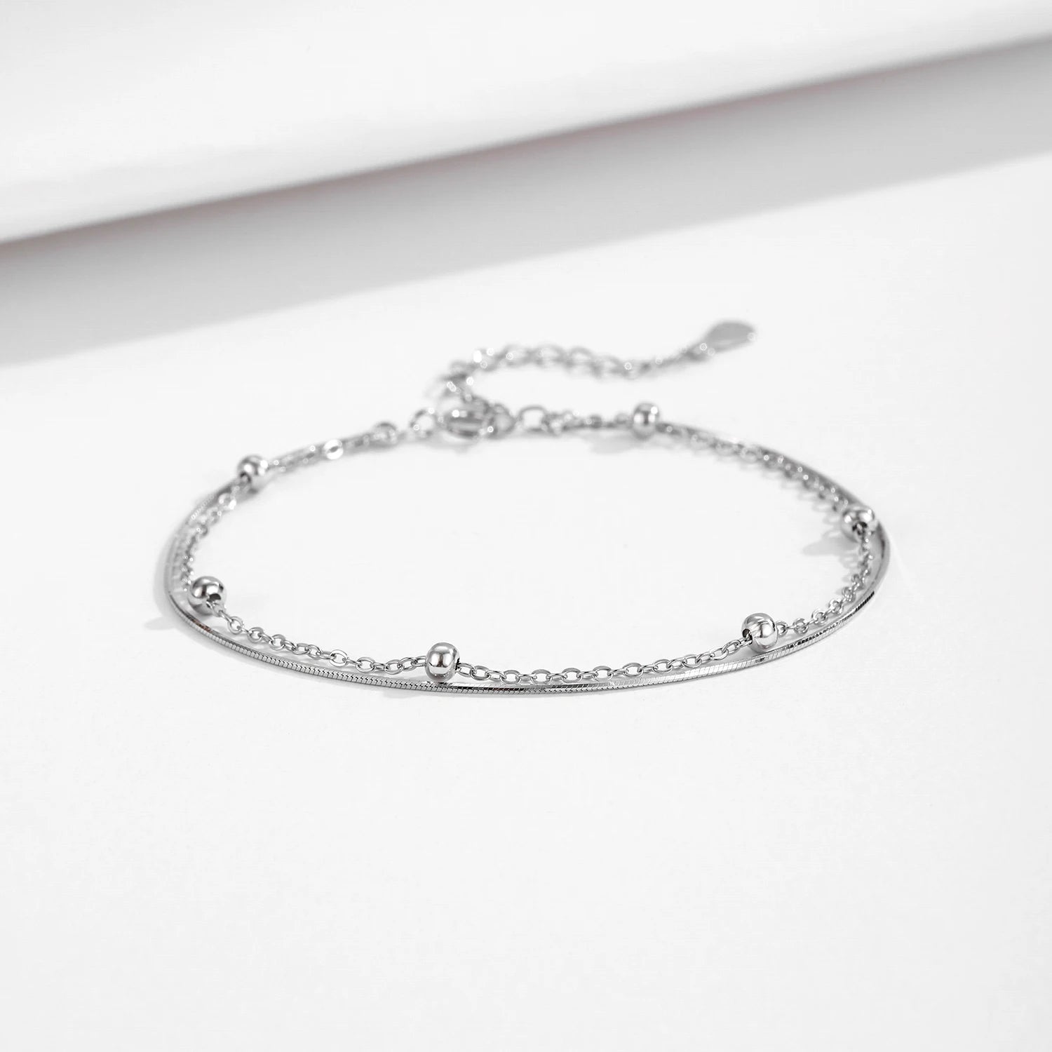 Chain and bracelet styling featuring a polished sterling silver bracelet