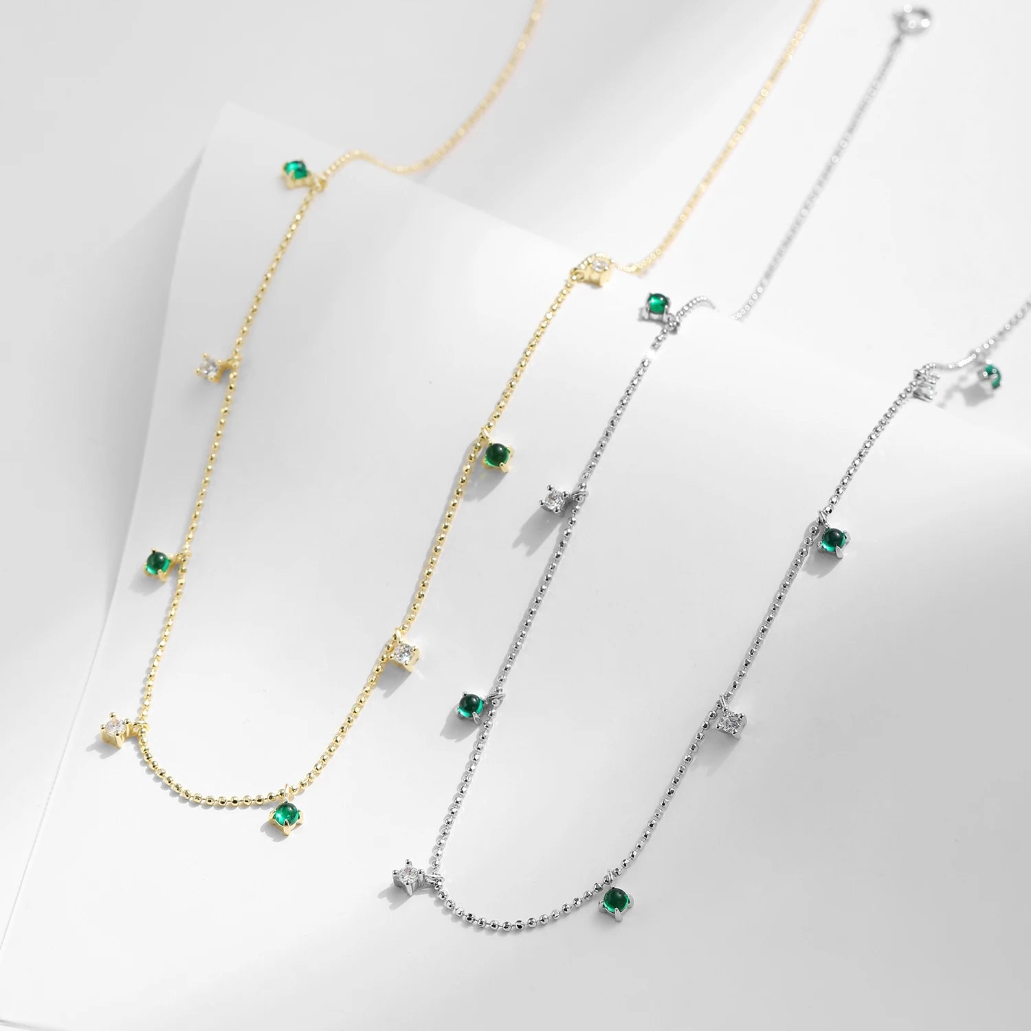 Charm necklace accent centered on a polished pendant necklace