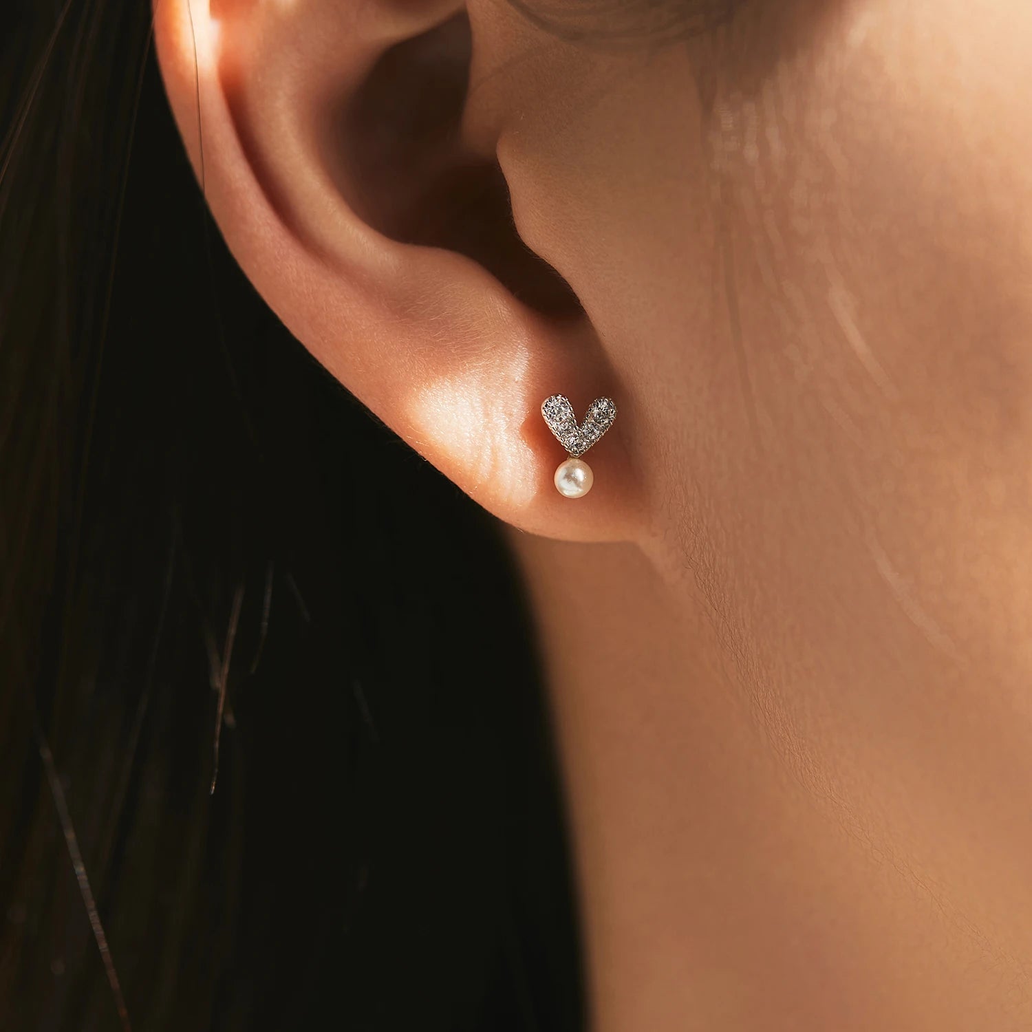 Close up of pearl stud earrings showing small pe arl and cz stones in silver earrings