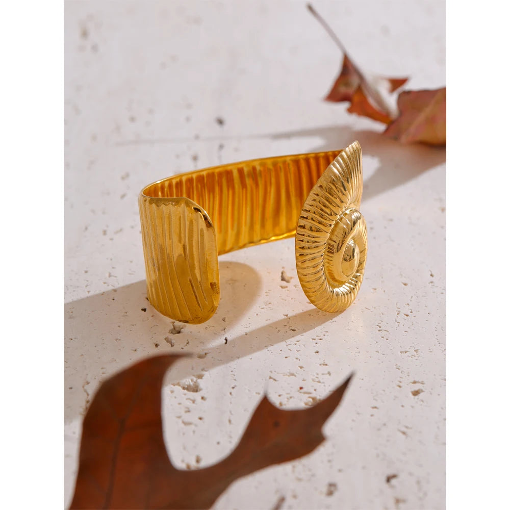 Clean background of gold bracelet bracelet with smooth open design