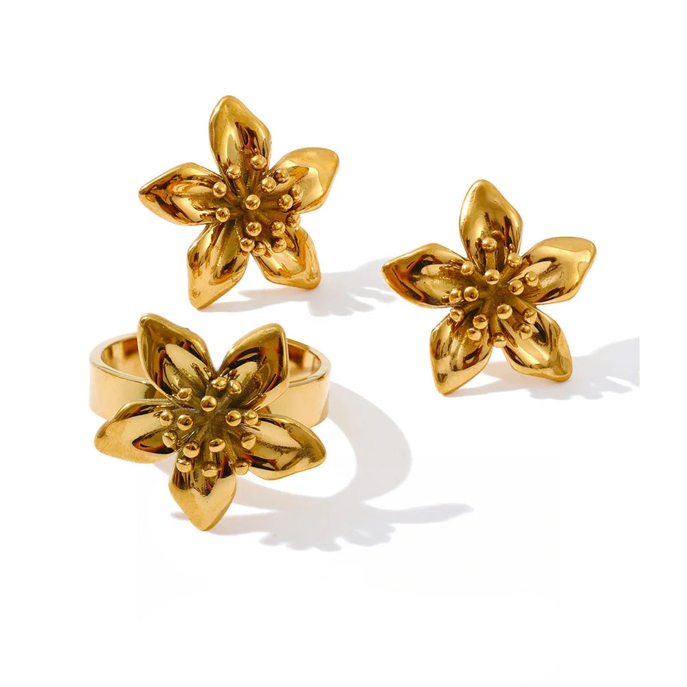 Earrings gold earrings with gold flower detail beside a matching gold ring