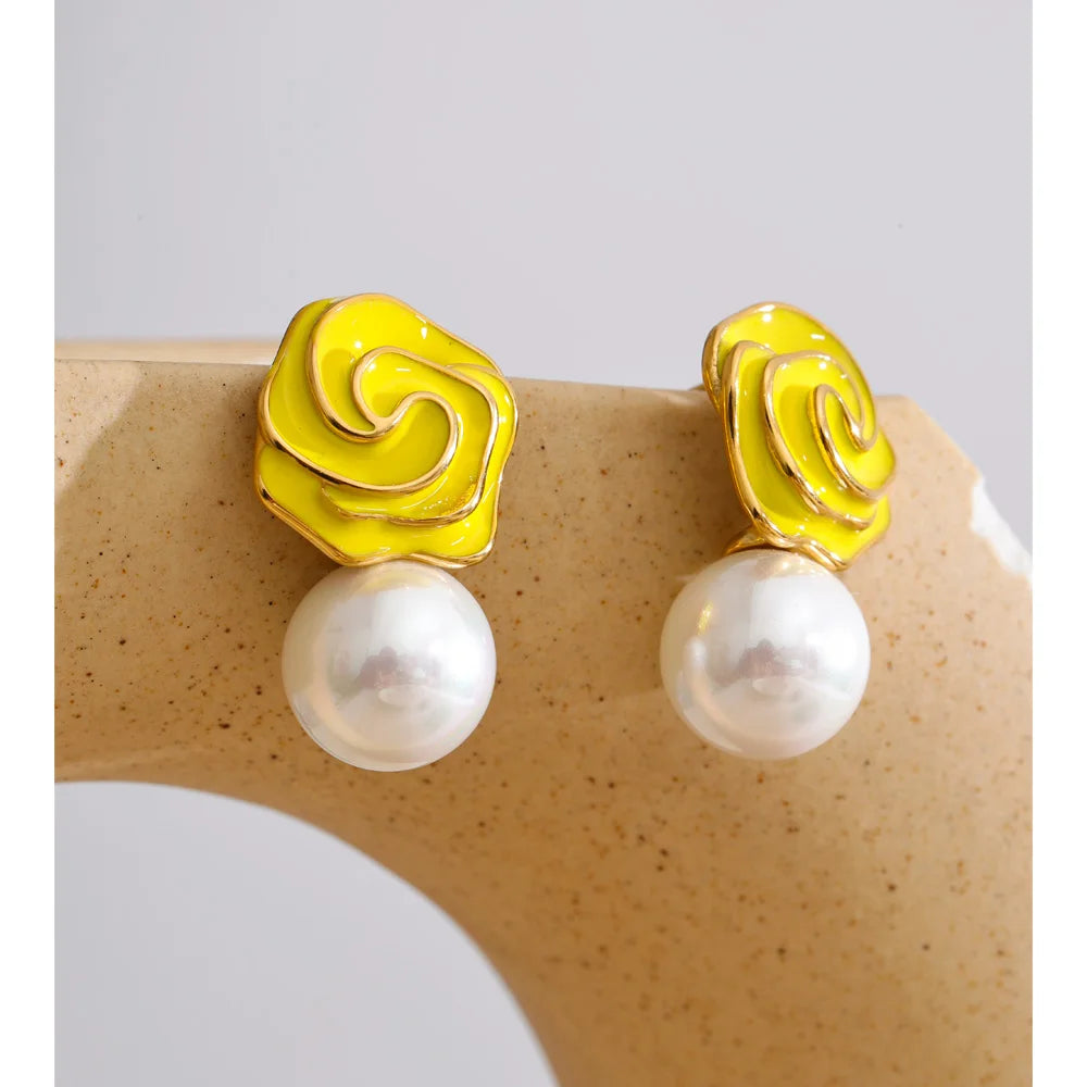 Close up of pearl stud earrings with enamel flower accent