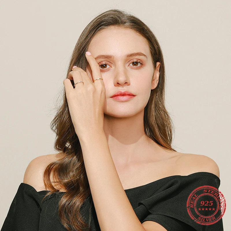 Close up of moissanite diamonds in a round engagement ring with silver band