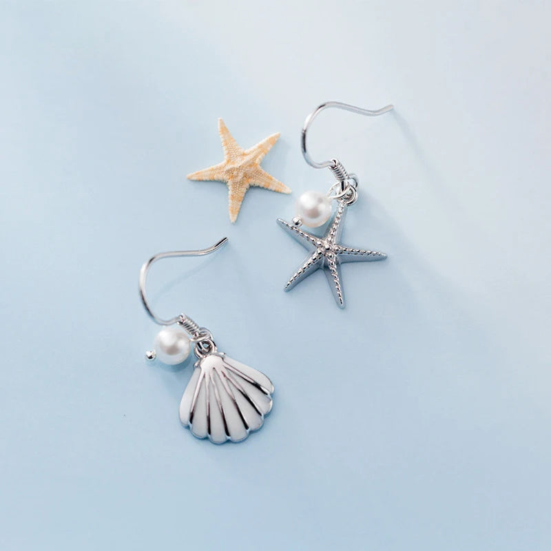 Shell dangle earrings featuring a starfish design and silver color shine