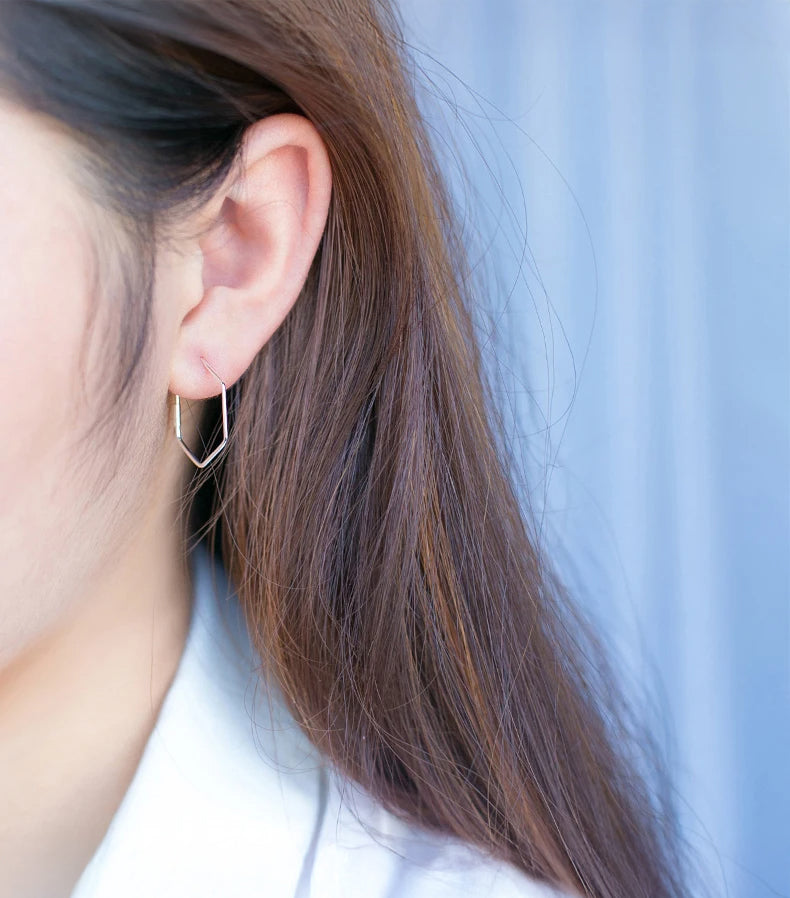 Silver hoop earrings with subtle diamond style detail photographed on velvet