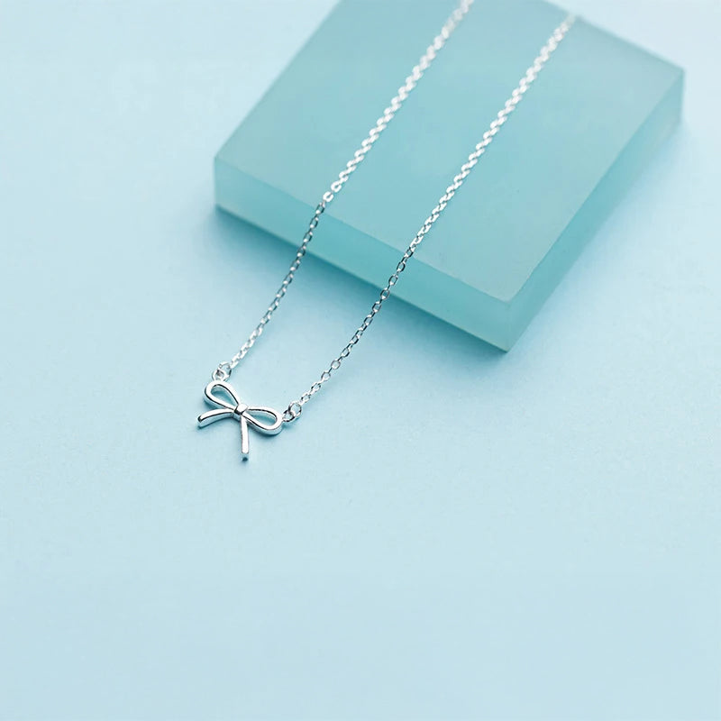 Silver necklace showing a delicate bowknot pendant necklace charm
