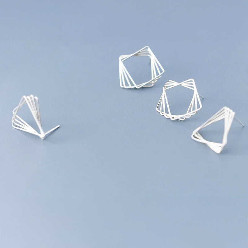 Minimal shot of silver earrings styled as modern stud earrings