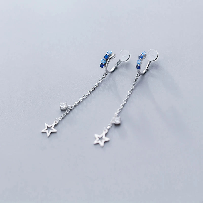 Woman wearing colorful earrings with star tassel and silver color clip backs