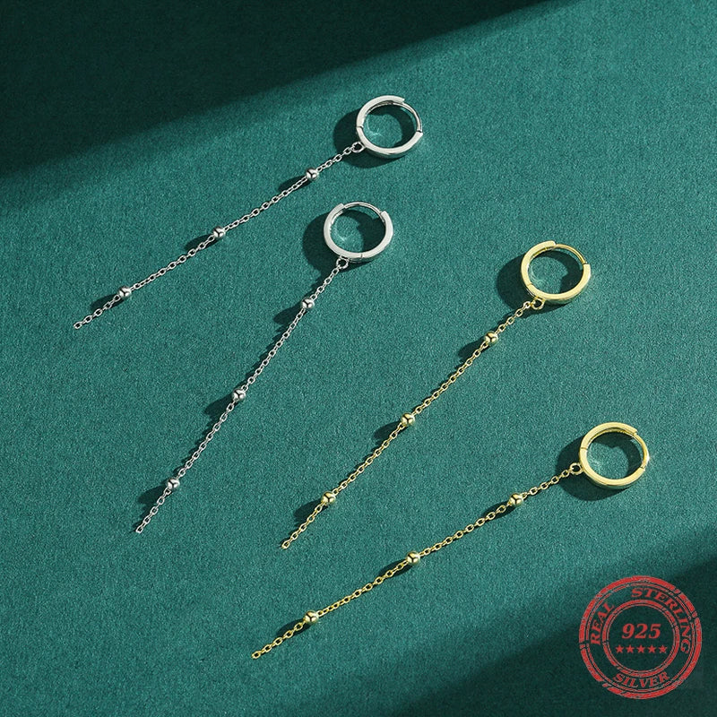 Sterling silver drop earrings styled to pair with silver hoops