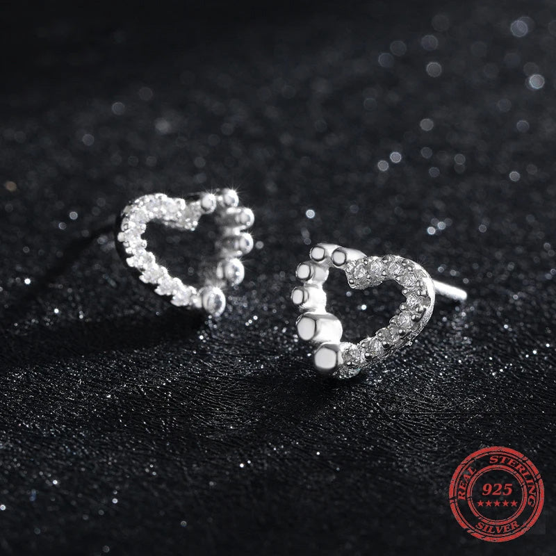 Sterling silver earrings showing tiny whimsical heart shapes with cz accents