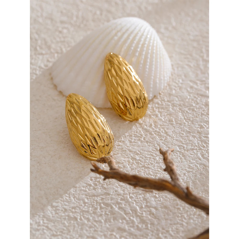 Close up of earrings and gold finish with refined texture