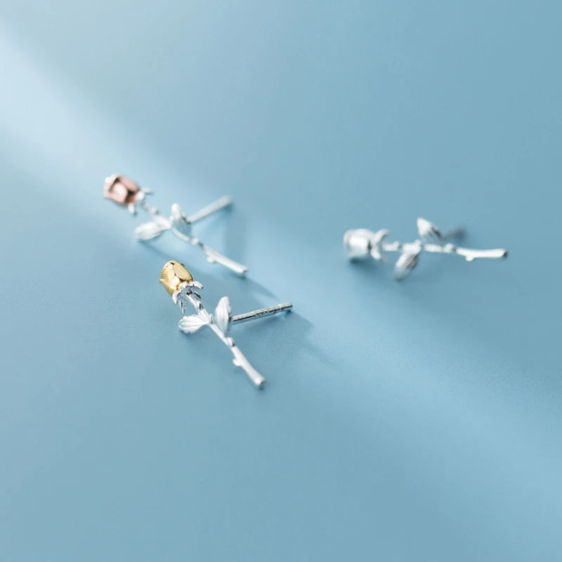 Close view of sterling silver earrings with rose gold and silver stud earrings style