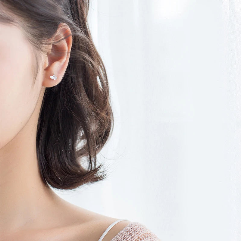 Classic stud earrings showing tiny floral design in silver color