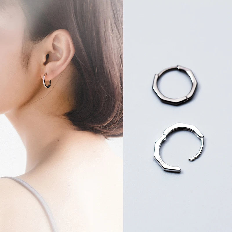 Silver color earrings with hoop silhouette shown on hoop earrings on women
