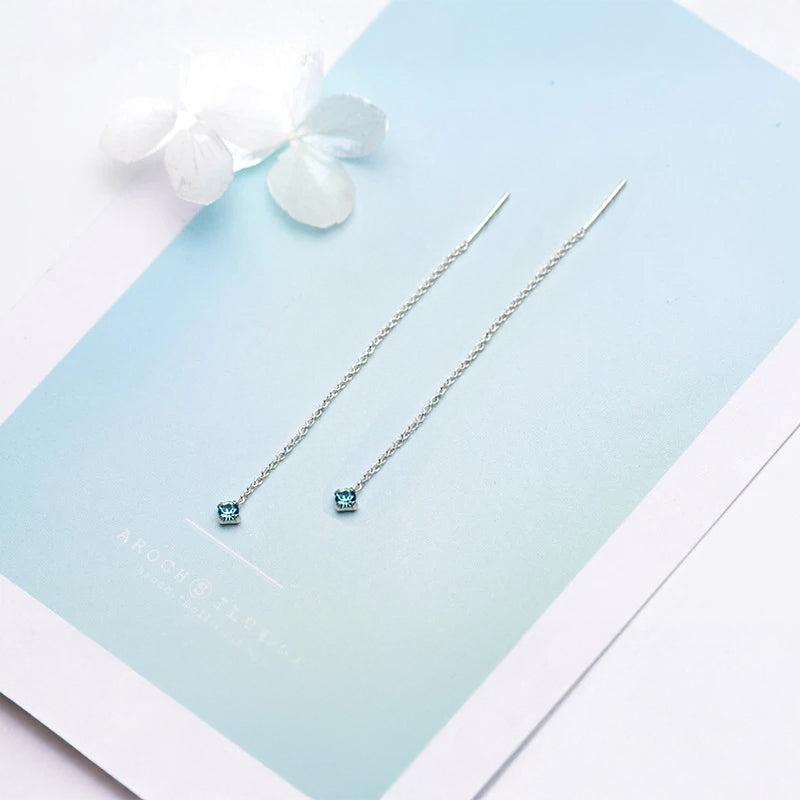 Delicate tassel drop earrings showcasing a luminous blue stone accent