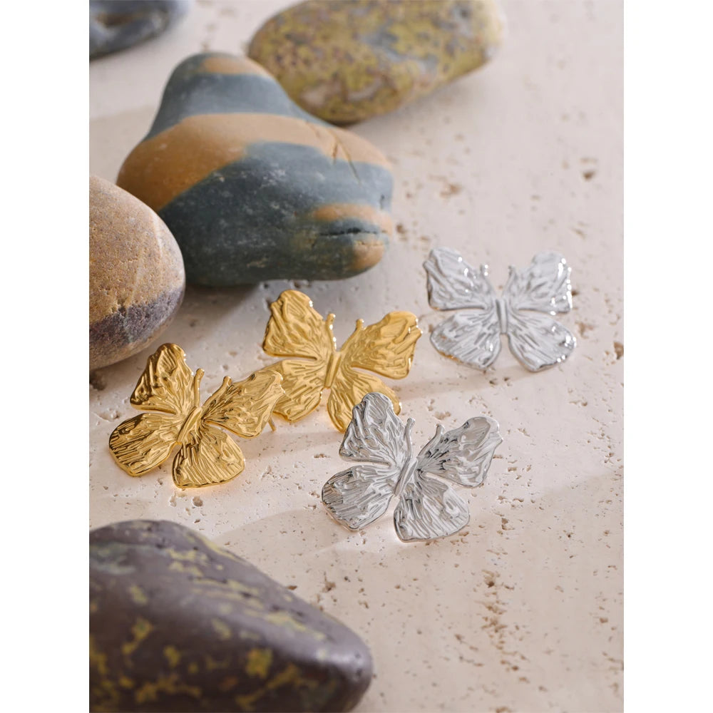 Flat lay of gold jewelry showcasing butterfly earrings gold plated detail