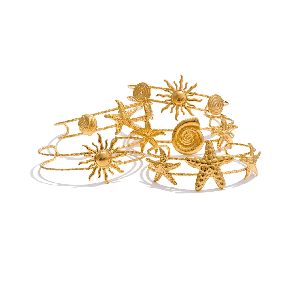 Ocean inspired gold bangle bracelet with starfish and shell motifs in gold plated shine