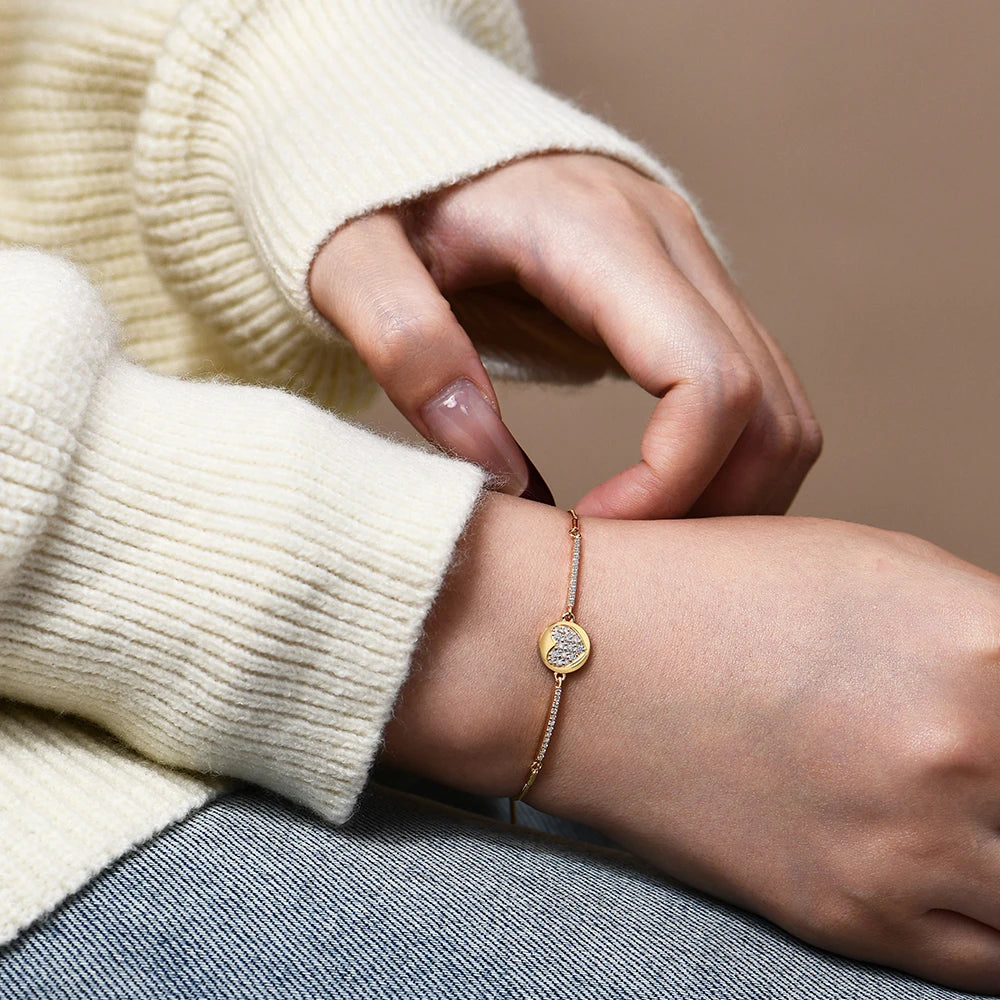 Close view of moissanite diamond on a gold heart bracelet