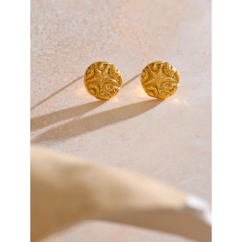 Close-up of starfish stud earrings with gold plated finish and subtle texture