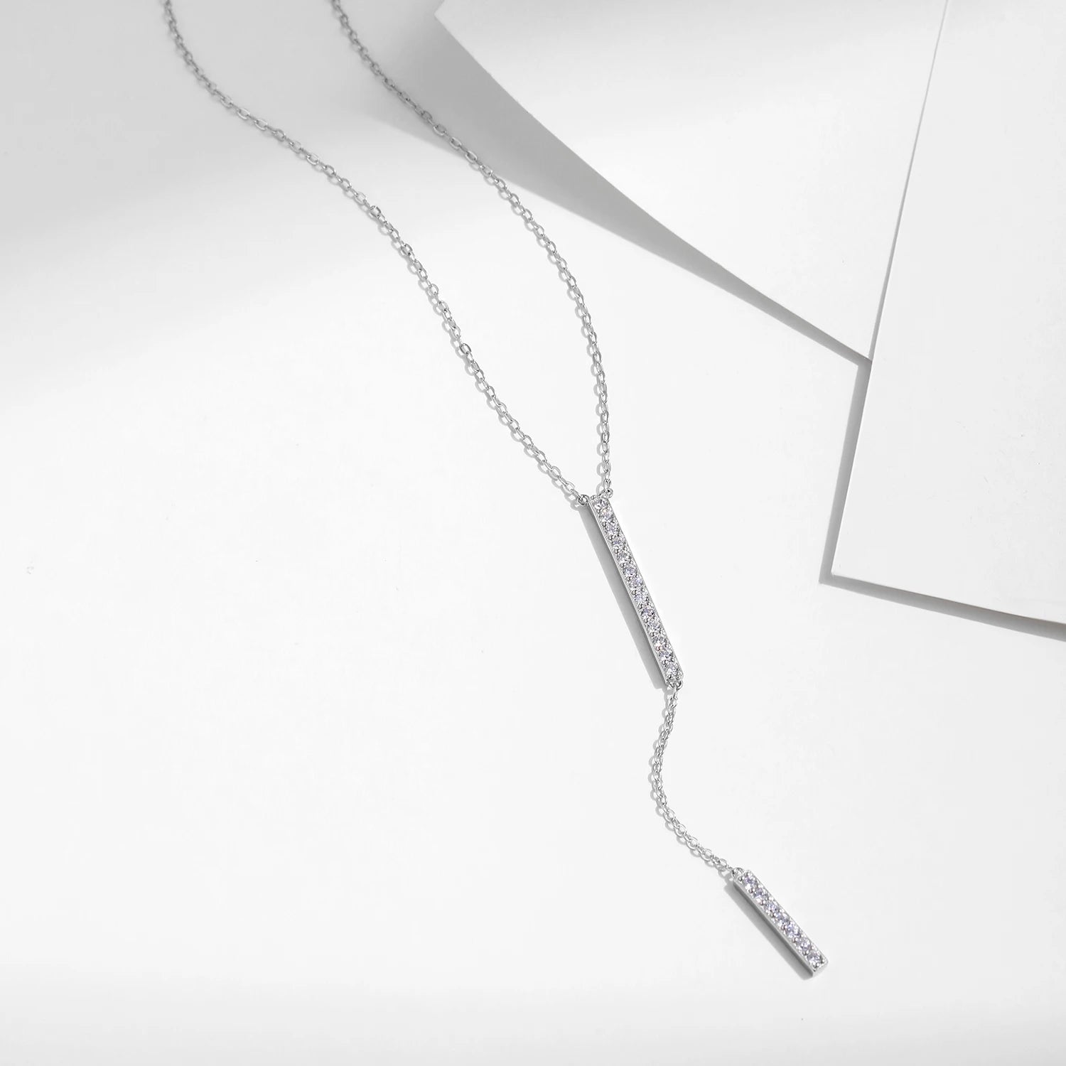 Silver necklace presented as a modern lariat with polished silver chain