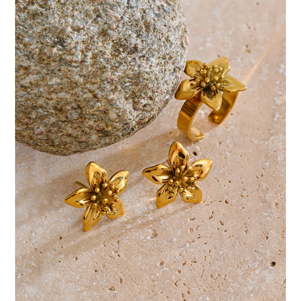 Stainless steel jewelry floral earrings paired with a gold ring ring