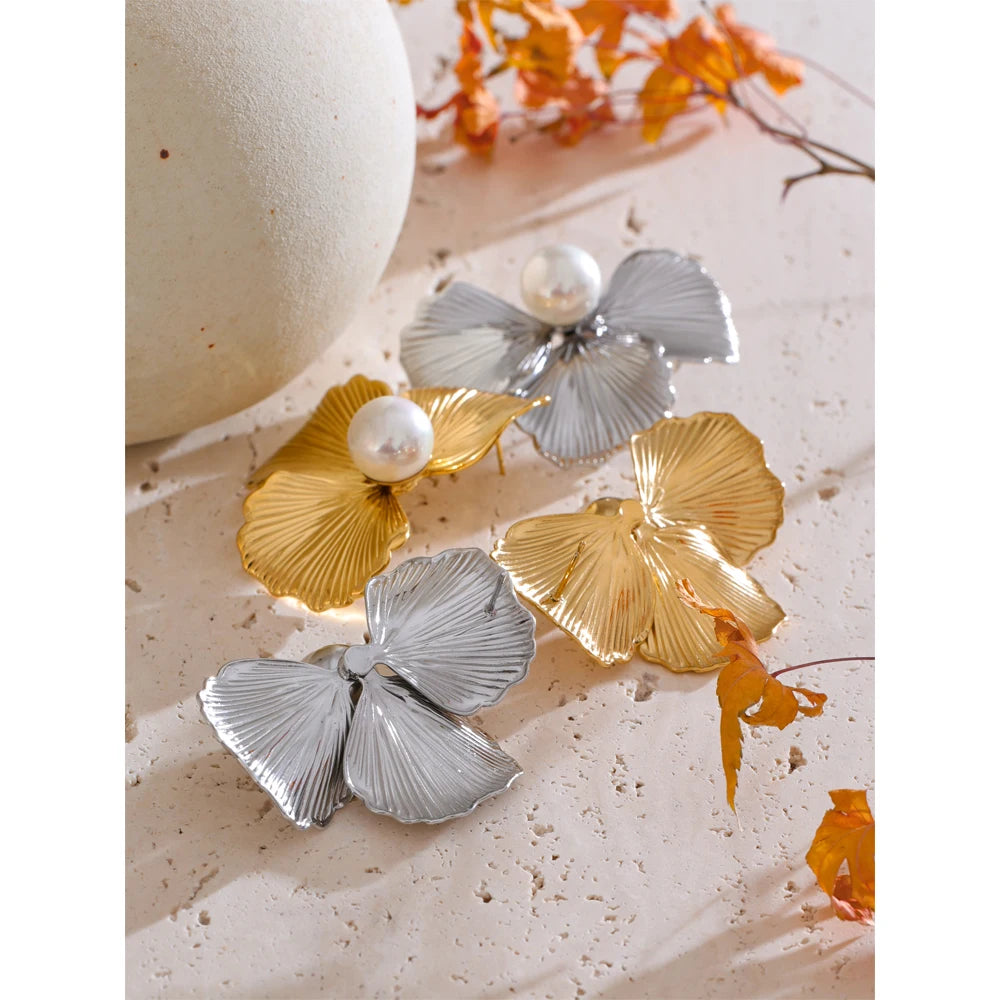 Lifestyle image styling earrings earrings gold beside a floral pearl centerpiece