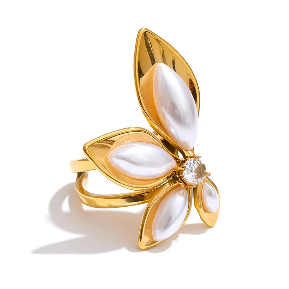 Finger with a ring featuring pearl and gold flower design