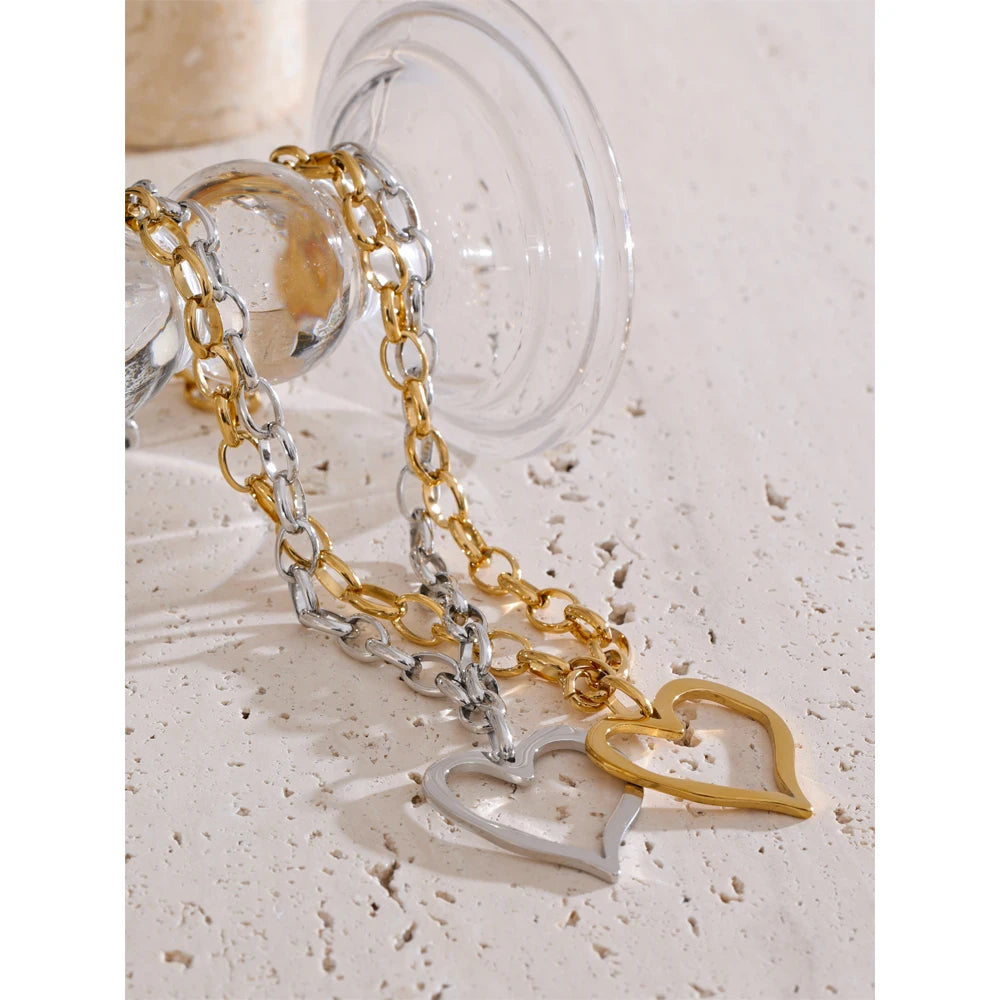 Close view of charm necklace showing gold heart on chain with gold finish