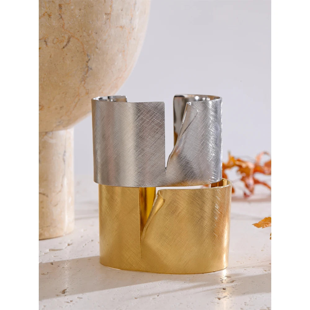 Fashion flat lay mixing bangle bracelet pieces with a wide stainless steel cuff