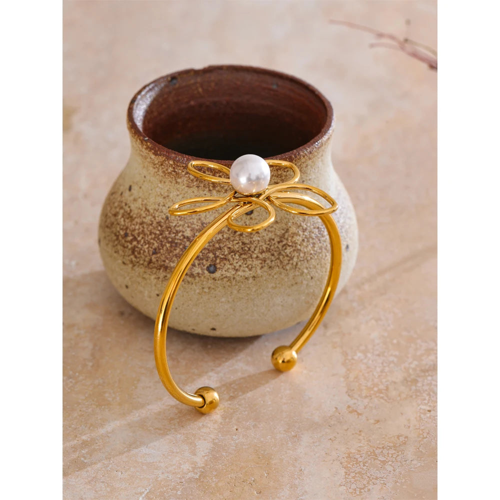 Open bangle bracelet showing pearl jewelry detail on a smooth cuff bracelet