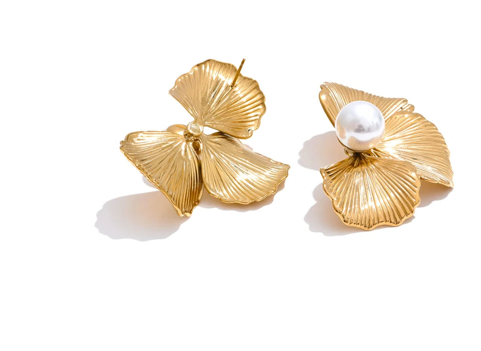 Macro detail of the petals framing pearl earrings in smooth gold plated polish