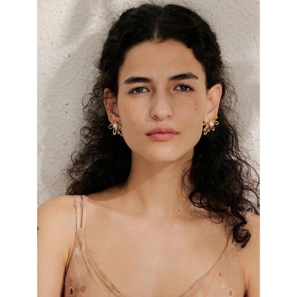 Close view of stud earrings showing pearl earrings center with polished petals