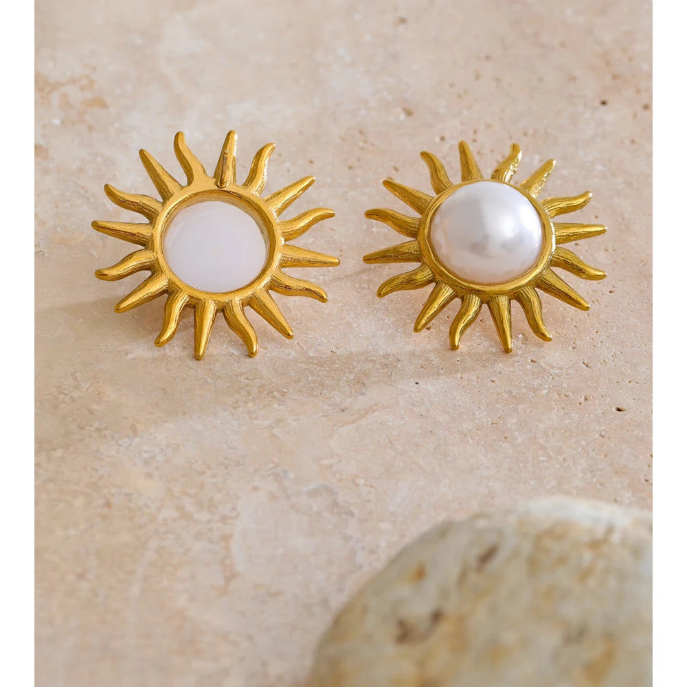 Golden jewelry earrings with sun motif and pearl centers