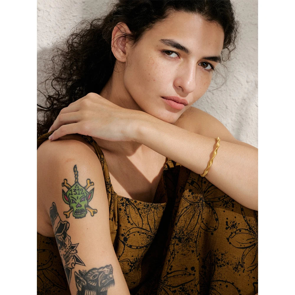 Close view of gold plated cuff bracelet showing smooth bangle bracelet curve