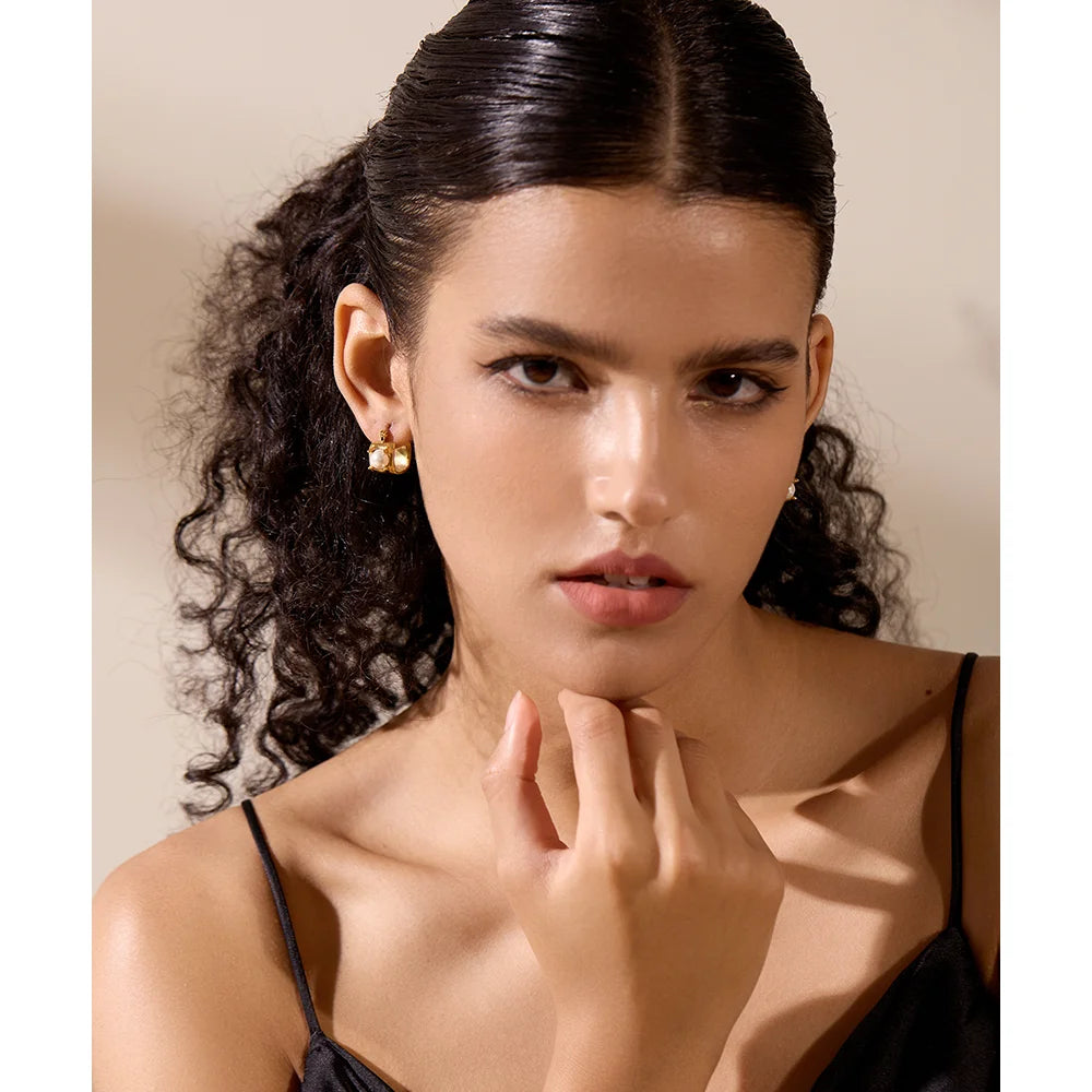 Elegant ear rings featuring a subtle pe arl accent in a hoop design