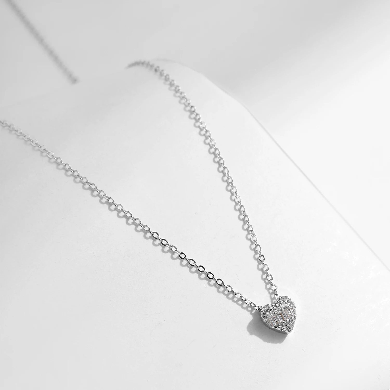 Sterling silver chain holding a heart in heart necklace charm with zirconia