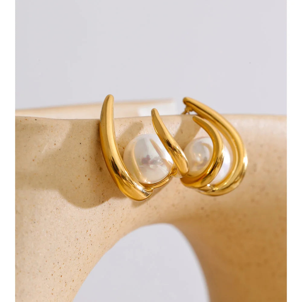 Close up of simulated pearl hoop earrings in gold plated finish