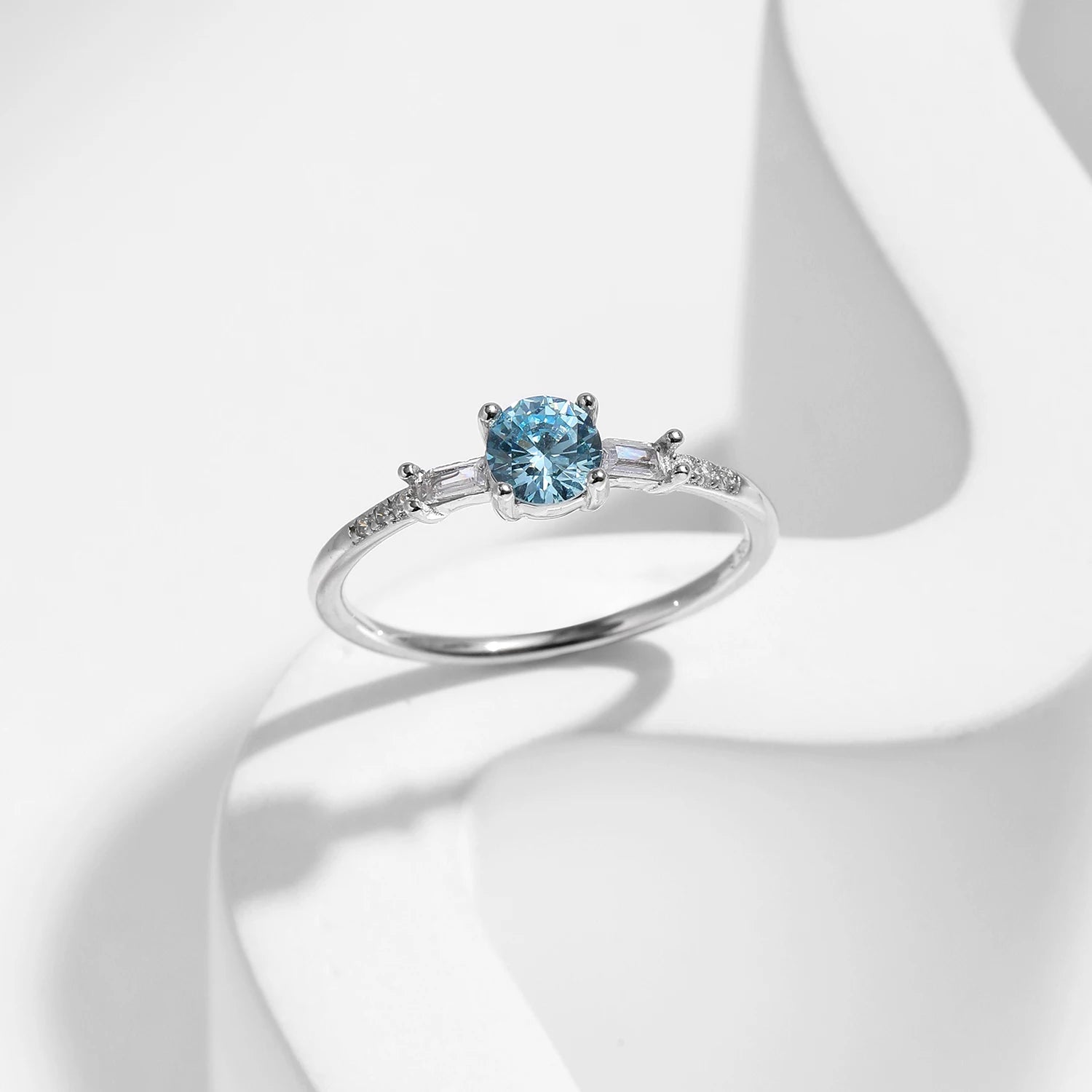 CZ ring in sterling silver featuring a round light blue stone