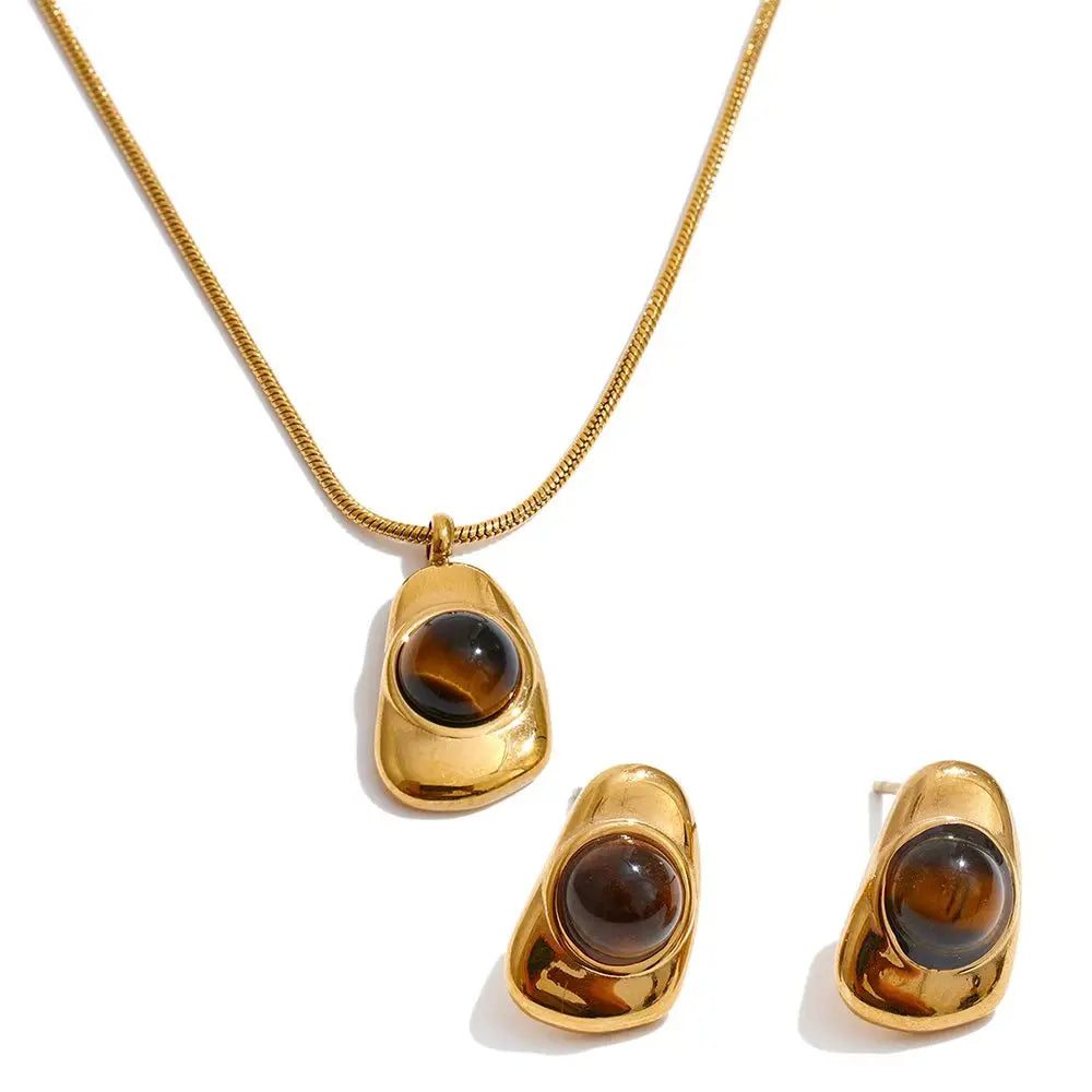 Lifestyle image where pearl for necklace touches complement tiger eye stone