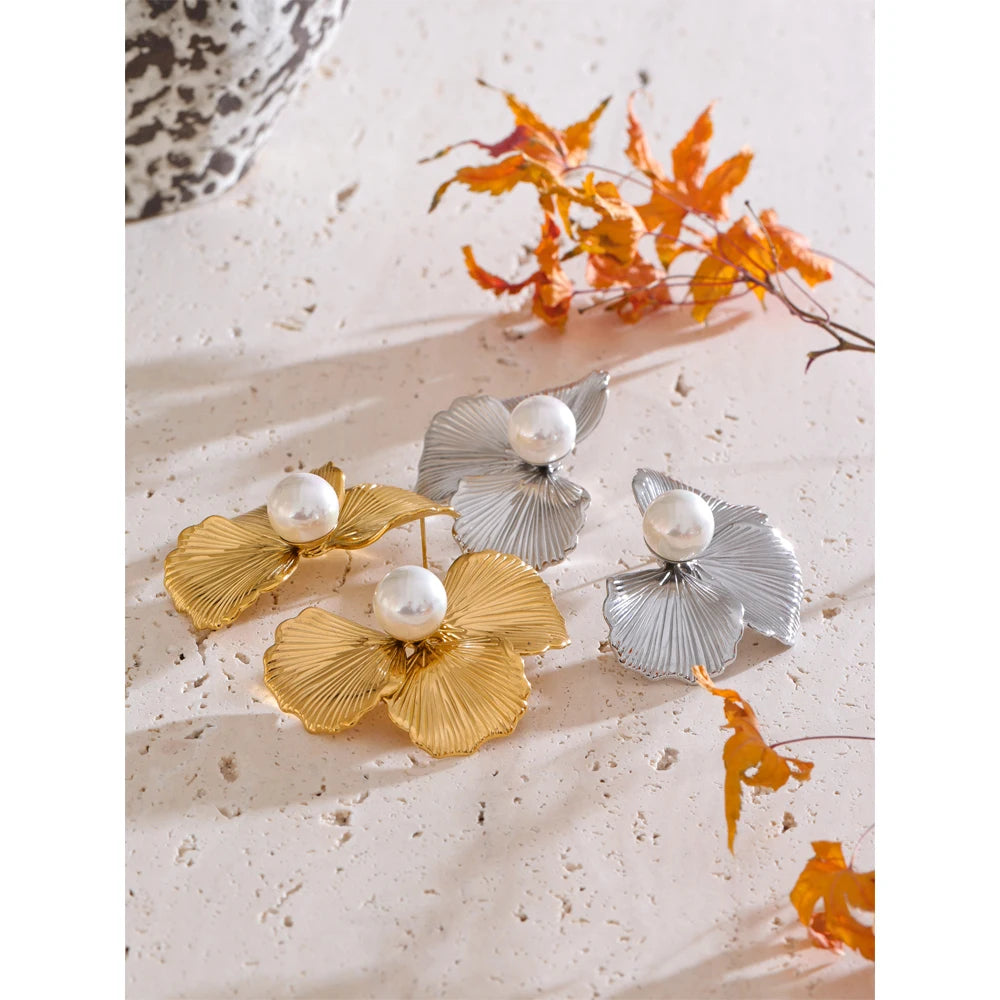 Fashion flat lay pairing earrings and gold accents with luminous pearl earrings