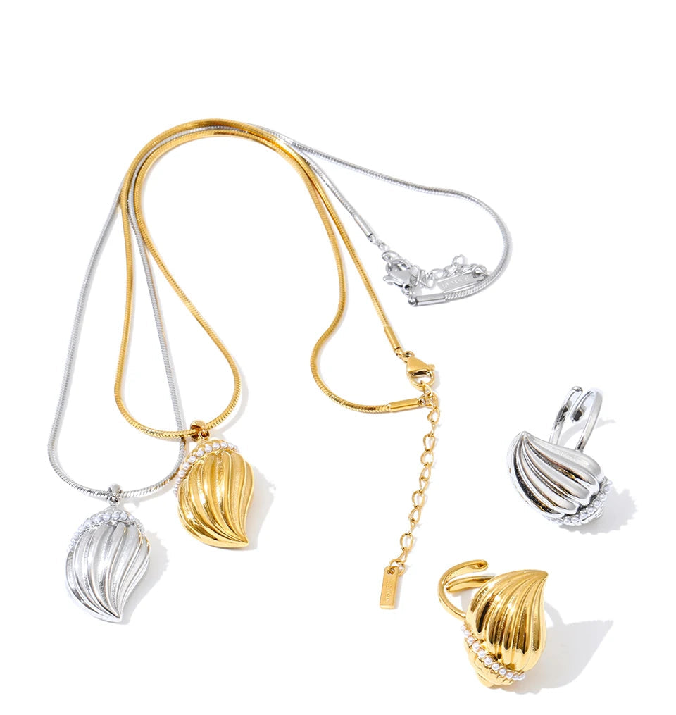 Minimal flat lay of charm necklace conch pendant next to coordinating pearl ring